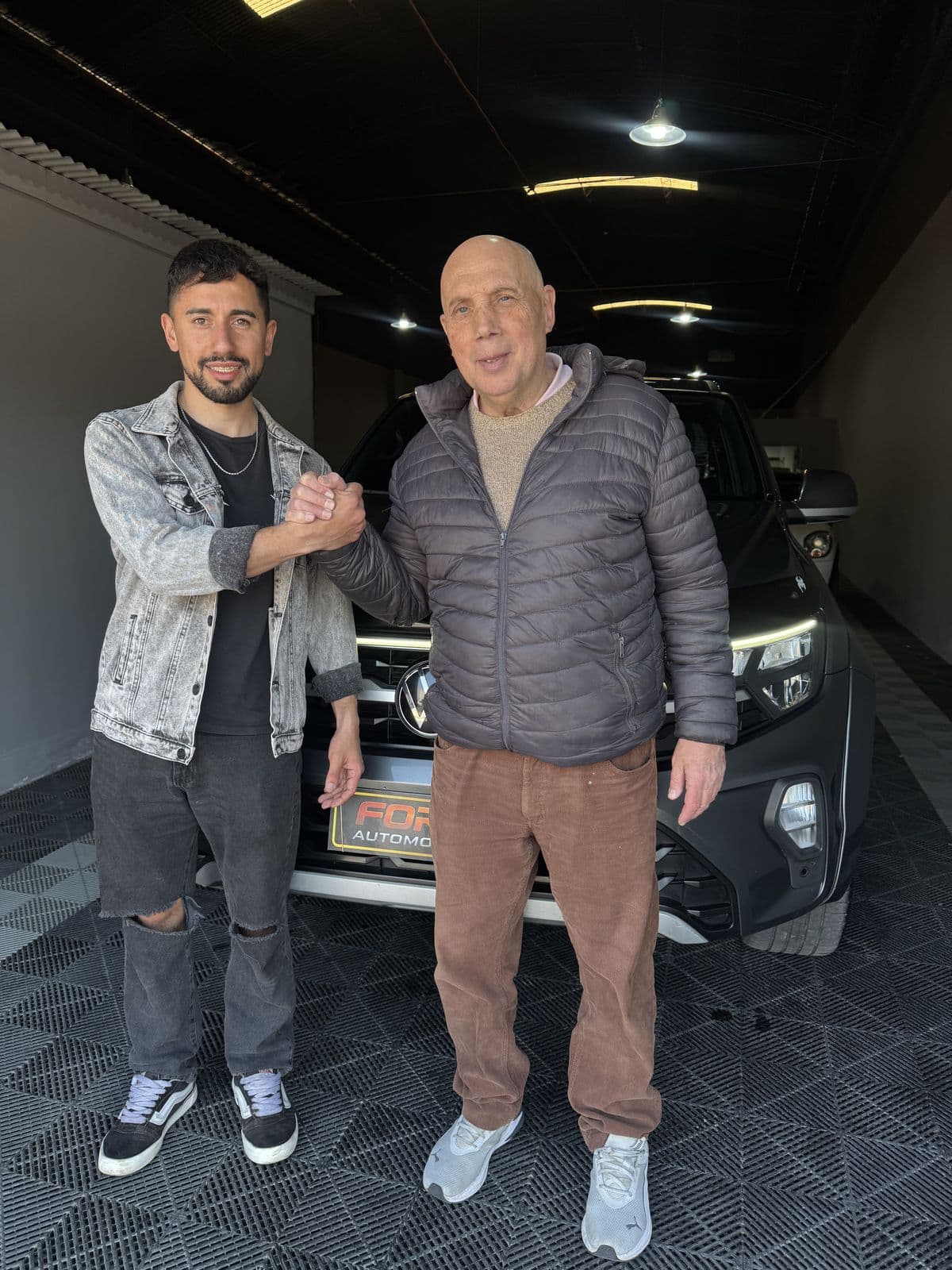 Una entrega en el showroom de Forja: apretón de manos delante de la camioneta