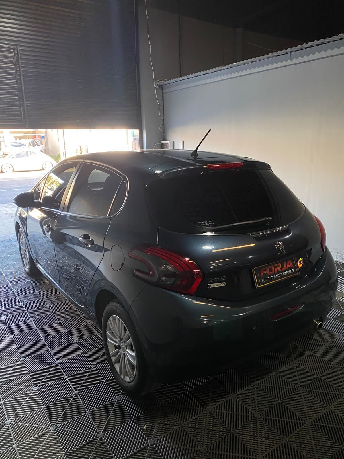 Peugeot 208 azul, tres cuartos de atrás del lado izquierdo