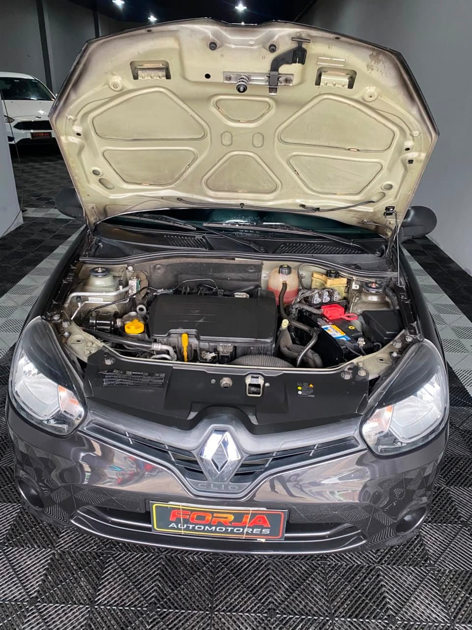 Renault Clio negro con el capot abierto, vano del motor de frente