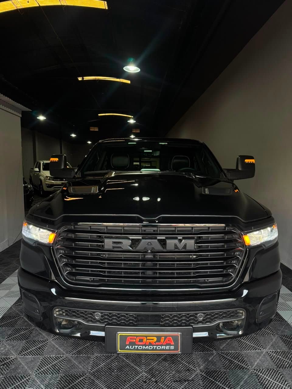 RAM 1500 negra de frente, con la parrilla RAM y las luces encendidas