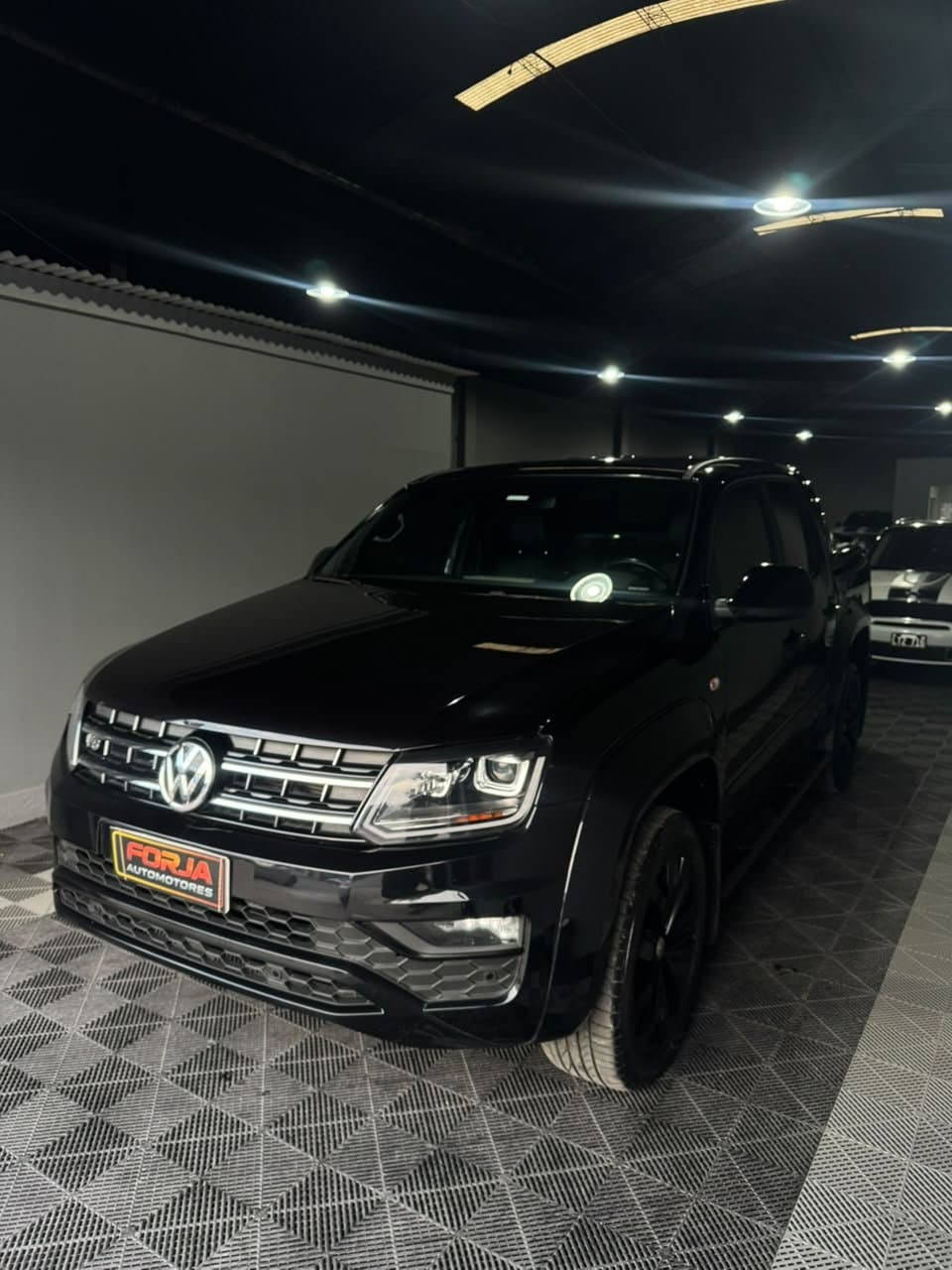 Amarok V6 negra, frente tres cuartos, en el showroom