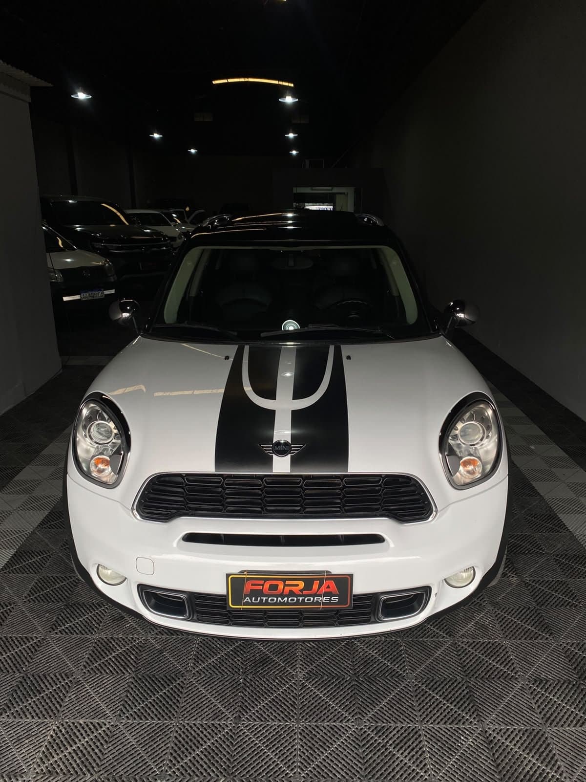 Mini Countryman blanco con franjas negras en el capot, de frente, en el showroom