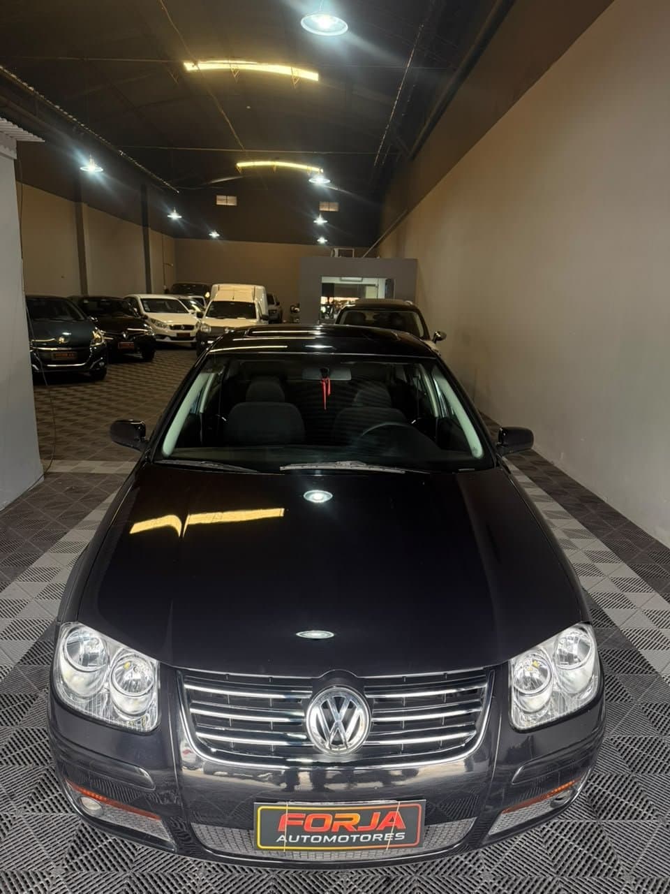 Volkswagen Bora negro de frente, en el showroom