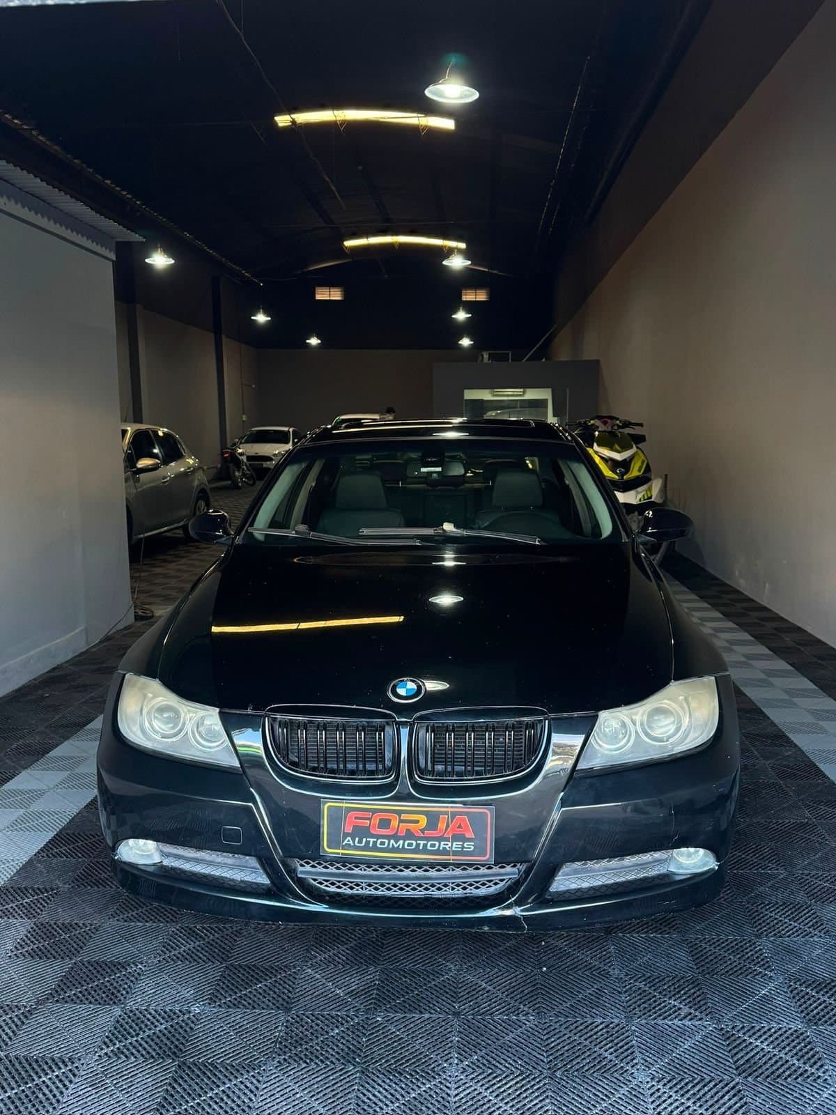BMW 328i negro de frente, en el showroom de Forja