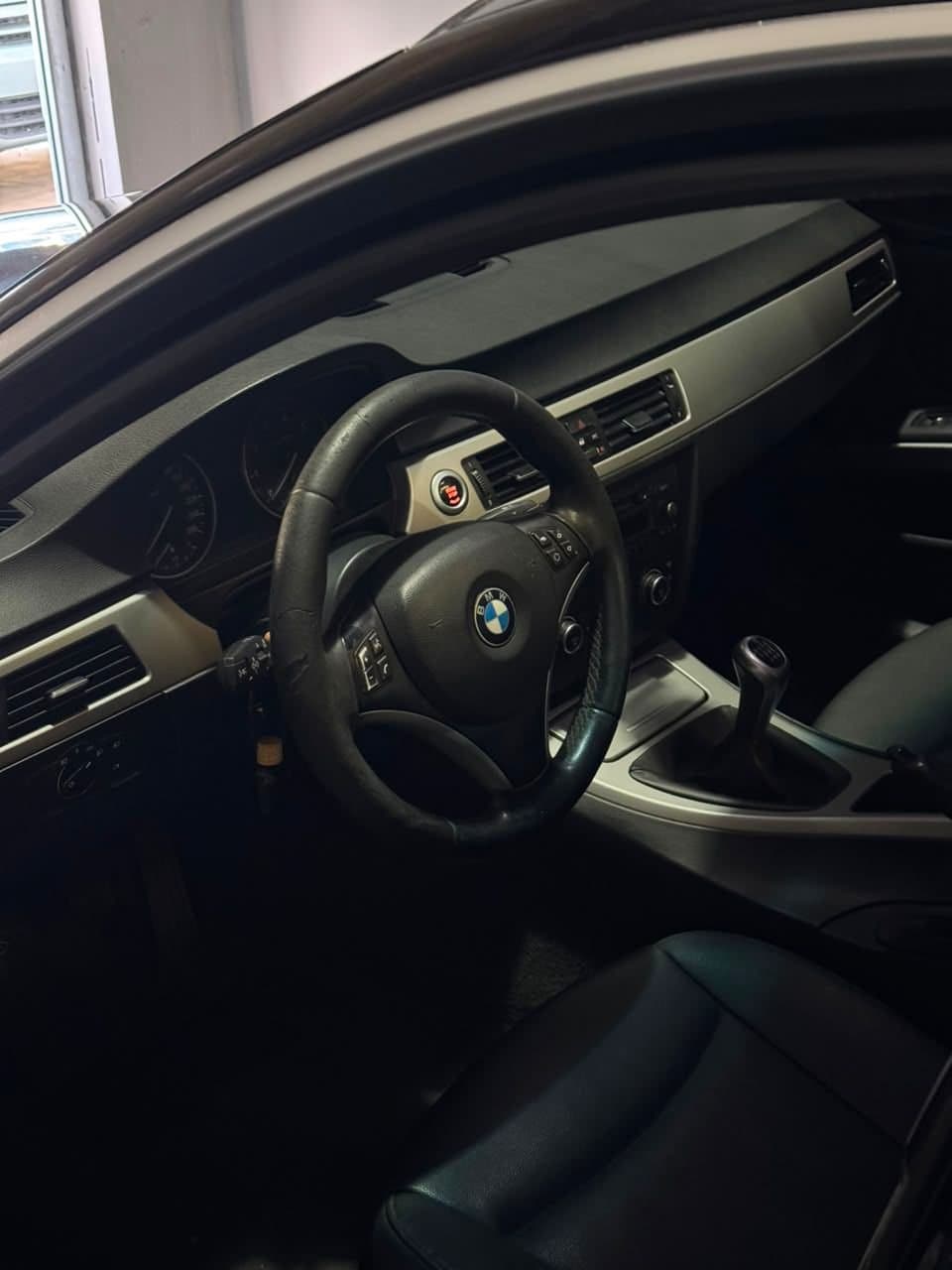 Puesto de manejo del BMW 328i desde la puerta, volante de cuero y caja manual